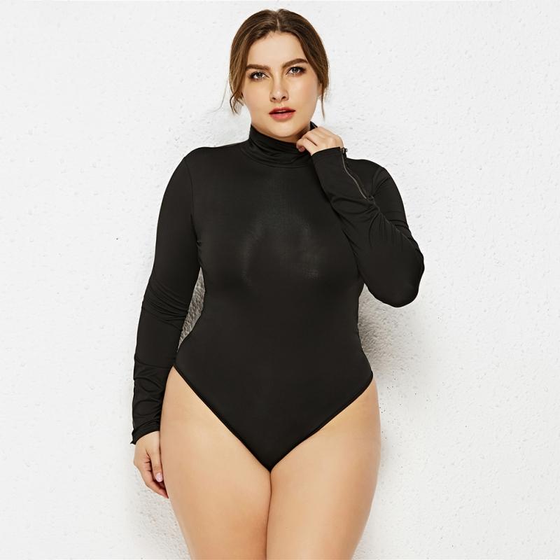 Femme portant du 50 en taille pose face avec body grande taille manches longues de couleur noir 